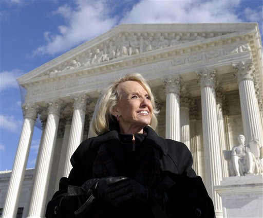 Arizona Gov. Jan Brewer stands outside the Supreme Court in Washington