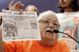 Local activist Salvador Reza, holds up a printout Reza says was circulated within the Maricopa County Sheriff's Office and evidence of racism in the department, during a news conference in the Maricopa County Board of Supervisors chambers Wednesday, May 11, 2011, in Phoenix.  Critics gathered and called for the resignation of Maricopa County Sheriff Joe Arpaio while asking the U.S. Attorney's Office to place the sheriff's office into receivership.  Arpaio's opponents are critical of nearly $100 million in misspent funds by his agency over eight years and a recent internal investigation that found mismanagement by his top commanders. (AP Photo/Ross D. Franklin)