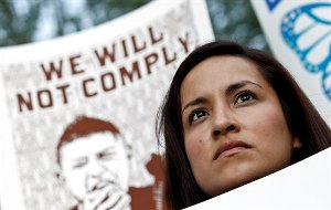 Diana Perez listens to speakers as she joins dozens who rally in front of U.S. Immigration and Customs Enforcement building, a day after a portion of Arizona's immigration law took effect, Wednesday, Sept. 19, 2012, in Phoenix. Civil rights activists contend will lead to systematic racial profiling, as the protesters chanted "No papers, no fear."(AP Photo/Ross D. Franklin)