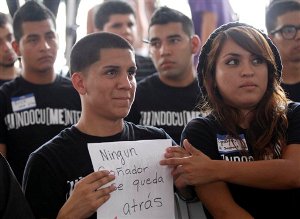 Jose Machado, left, holds a sign in Spanish that reads "No Dreamer left Behind" during a news conference of students seeking temporary relief from deportation in Miami, Tuesday, Aug. 15, 2012. Hundreds of thousands of young illegal immigrants scrambled to get papers in order Wednesday as the U.S. started accepting applications to allow them to avoid deportation and get a work permit but not a path to citizenship. (AP Photo/Alan Diaz)