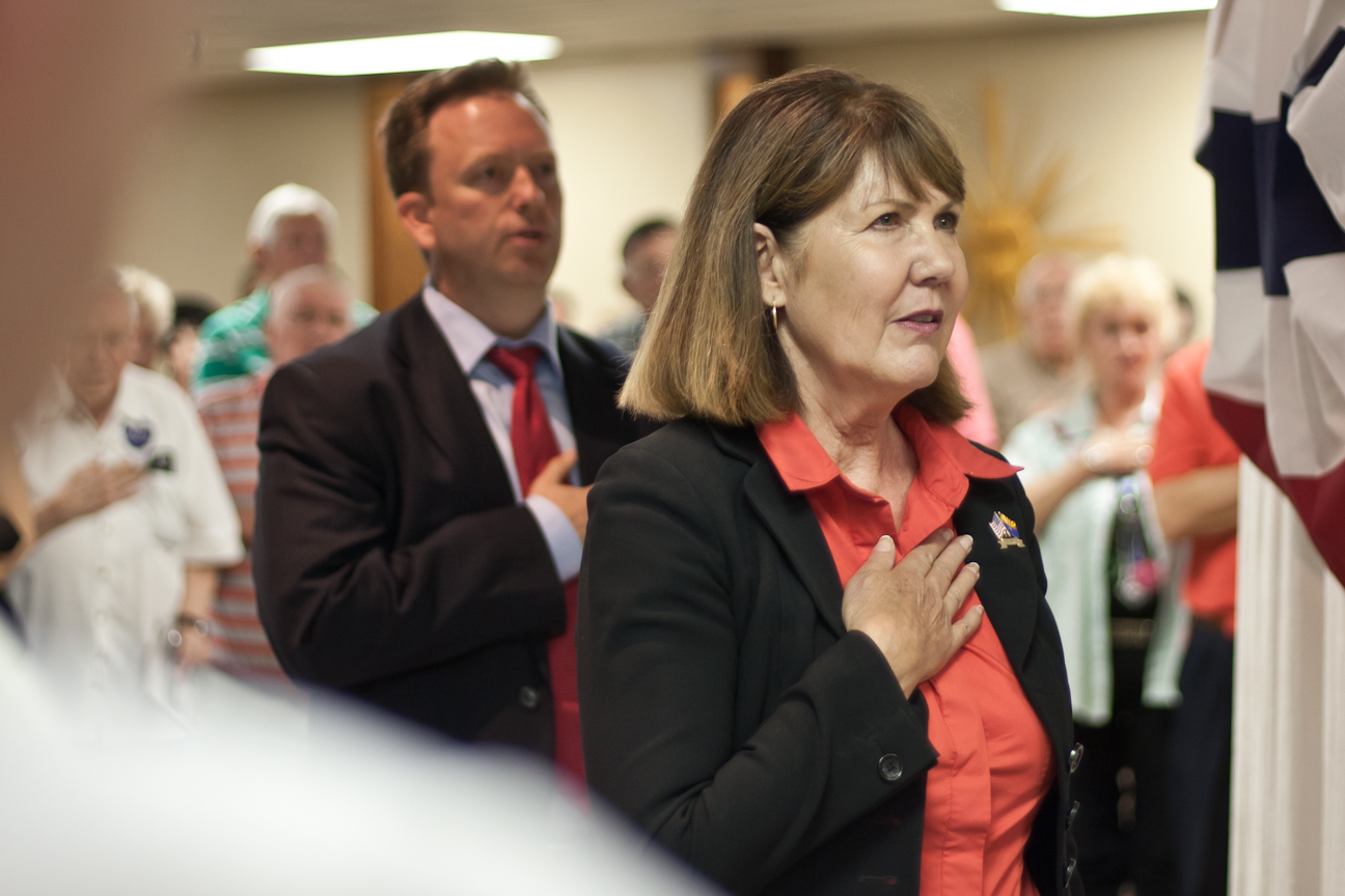 Former U.S. Rep. Ann Kirkpatrick (foreground) and former state Sen. Jonathan Paton pledge allegiance before their Oct. 4 debate. (Photo by Evan Wyloge/Arizona Capitol Times)