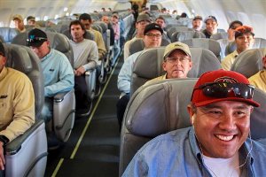 Jesus Rodriguez, lower right, and 61 other Salt River Project and Arizona Public Service workers sit aboard a Spirit Airlines chartered flight to go to Long Island, N.Y. to help restore electricity in the aftermath of Superstorm Sandy, Friday, Nov. 2, 2012 in Mesa, Ariz. The 21 line crews and support staff expect to be in New York for about two weeks to assist the restoration that has left millions on the East Coast without power since the storm hit on Monday. (AP Photo/The Arizona Republic, Charlie Leight)