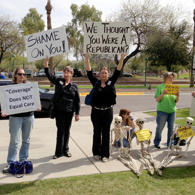 Detractors of Gov. Jan Brewer's Medicaid expansion proposal protest at her rally at the state Capitol. (Photo by Jeremy Duda/Arizona Capitol Times)