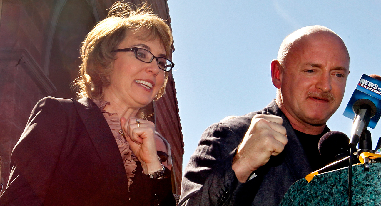 Former Rep. Gabrielle Giffords, left, shouts "fight, fight, fight" as she and husband, Mark Kelly, pump their fists together as they returned to the site of a shooting that left Giffords critically wounded on Wednesday, March 6, 2013, in Tucson, Ariz. Giffords urged senators to pass background checks for gun purchases. (AP Photo/Ross D. Franklin)