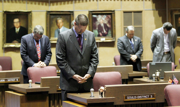 In this June 13, 2011 file photo, from left, Sen. Steve Yarbrough, R-Chandler, Sen. Ron Gould, R-Lake Havasu City, Sen. Adam Driggs, R-Phoenix, and Sen. Steve Smith, R-Maricopa, all bow their heads in prayer for those involved in the wildfires in Arizona during a special session in the senate chambers at the Capitol in Phoenix. Smith, a conservative Christian, said Wednesday, May 22, 2013, that the prayer offered by Democratic Rep. Juan Mendez (not shown), an atheist, at the beginning of the previous day's floor session wasn't a prayer at all. So he asked other members to join him in a second daily prayer in "repentance." (AP Photo/Ross D. Franklin, File)