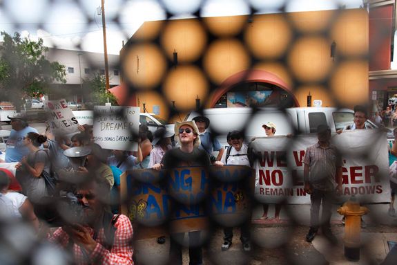 Immigration activists demonstrate on the U.S. side of the border fence as they wait for "dreamers" to arrive to the U.S. port of entry where they planned to request humanitarian parole, seen from Nogales, Mexico, Monday, July 22, 2013. Customs and Border Protection officials on Monday detained the activists who filed applications for humanitarian parole at the Nogales border crossing to try to return to the United States. (AP Photo/Samantha Sais)