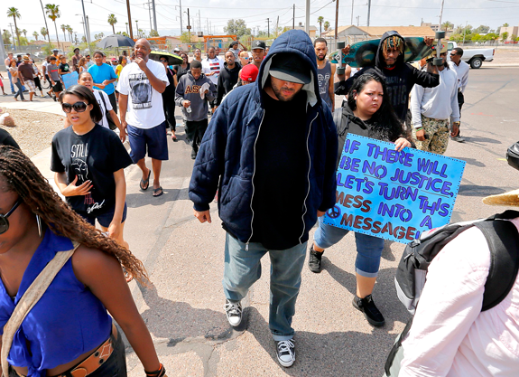 Story Russ, center, walks in a community march for "Justice for Trayvon" Monday, July 22, 2013 in Phoenix. Dozens of people participated in a protest march in Phoenix on Monday, calling for federal civil rights charges to be filed against Florida neighborhood watch activist George Zimmerman. A Florida jury acquitted Zimmerman in the shooting death of Trayvon Martin. (AP Photo/Matt York)