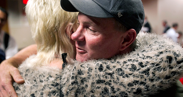 Dan Parker, right, the father of Wade Parker, who died fighting the Yarnell Hill Fire, receives a hug following an Industrial Commission of Arizona hearing on Wednesday, Dec. 4, 2013, in Phoenix. The commission approved a nearly $560,000 fine on Wednesday against the state Forestry Division in the deaths of 19 firefighters after the Arizona Division of Occupational Safety and Health agency found that officials put protection of property ahead of safety and should have pulled out crews earlier. (AP Photo/The Arizona Republic, David Wallace)