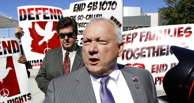 In this Feb. 10, 2011 file photo, protesters gather around former state senator Russell Pearce, author of SB 1070. The ACLU acquired thousands of Pearce e-mails through a public records request and says they prove the controversial anti-immigration law was racially motivated. (Matt York/Associated Press)