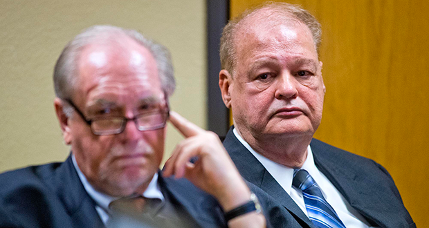 Attorney Michael Kimerer, left, and Arizona Attorney General Tom Horne, right, listen to arguments from Yavapai Deputy County Attorney Benjamin Kreutzberg, in a hearing into allegations that Horne and political ally Kathleen Winn, violated campaign finance laws. Horne's attorney, Michael Kimerer is at left. (Photo by Tom Tingle/The Arizona Republic)