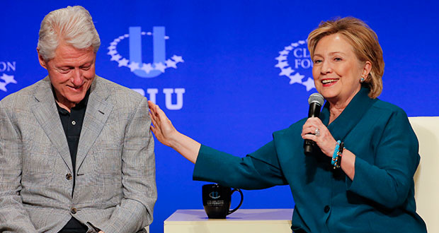 Former President Bill Clinton, left, listens as former Secretary of State Hillary Rodham Clinton speaks during a student conference for the Clinton Global Initiative University, Saturday, March 22, 2014, at Arizona State University in Tempe, Ariz. More than 1,000 college students are gathered at Arizona State University this weekend as part of the Clinton Global Initiative University's efforts to advance solutions to pressing world challenges. (AP Photo/Matt York)