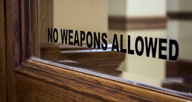 A sign on the door of the Montana Capitol in Helena tells visitors not to bring weapons. (Photo by Justine McDaniel/News21)