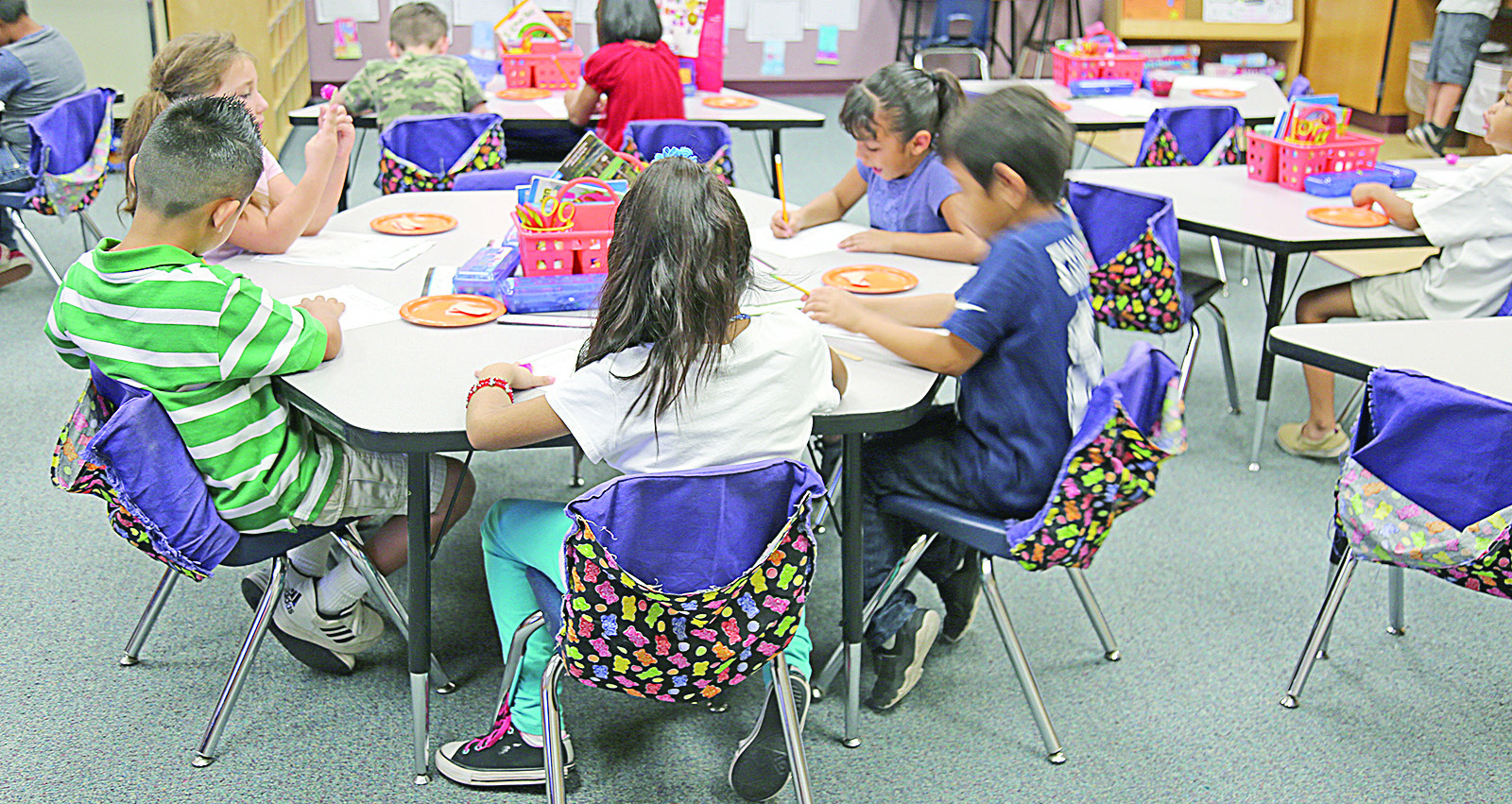 First graders in Irene Hammerquist's class at Bales Elementary School put together paper pumpkins decorated with fall-themed spelling words. Hammerquist said she teaches all of her students that sometimes a lesson has to be taught in a variety of ways to reach everyone. (Photo by Katie Campbell/Arizona Capitol Times)