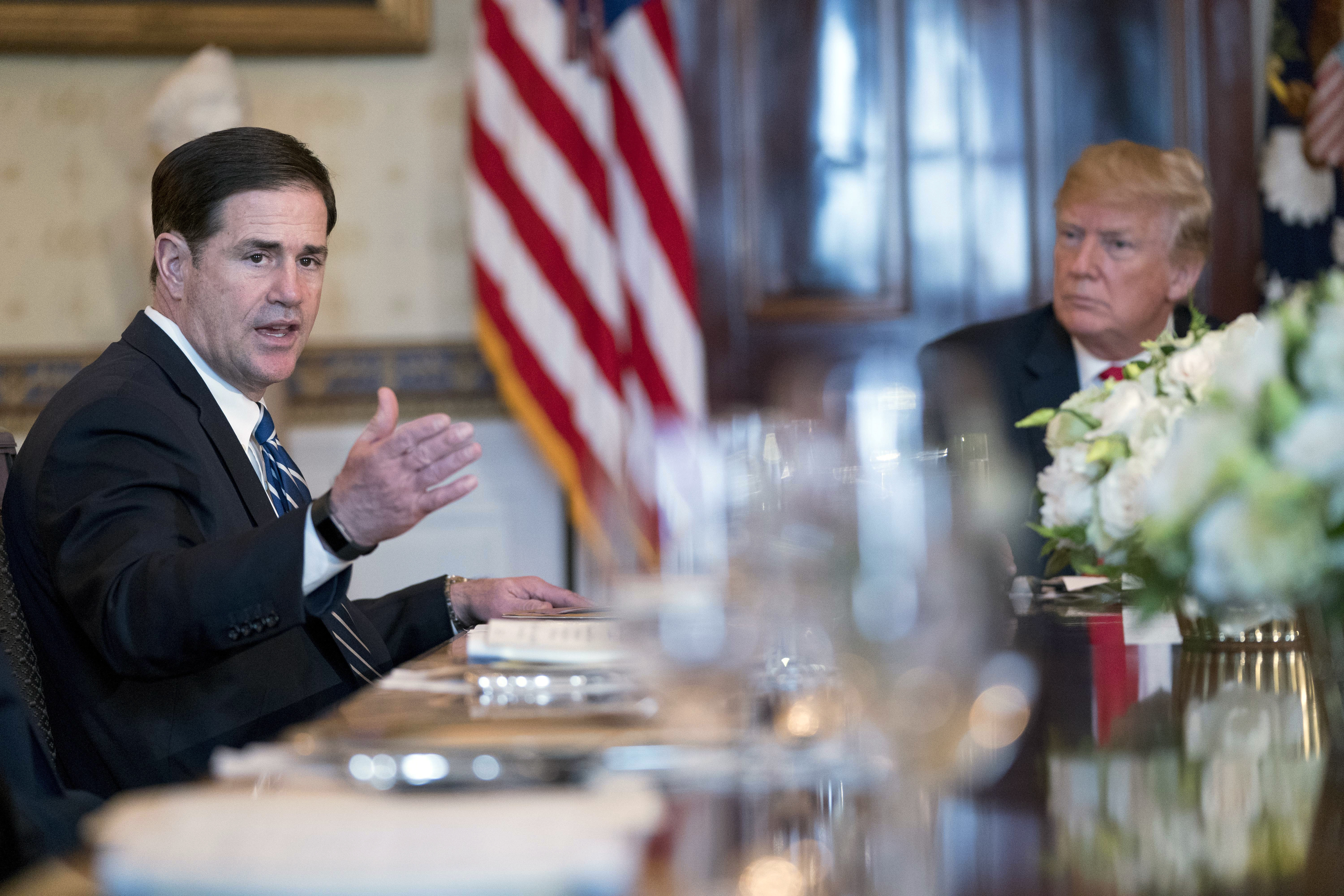 Arizona Gov. Doug Ducey, left, accompanied by President Donald Trump, right, speaks during a meeting with governors in the Blue Room of the White House in Washington, Monday, May 21, 2018, to discuss border security and restoring safe communities. (AP Photo/Andrew Harnik)