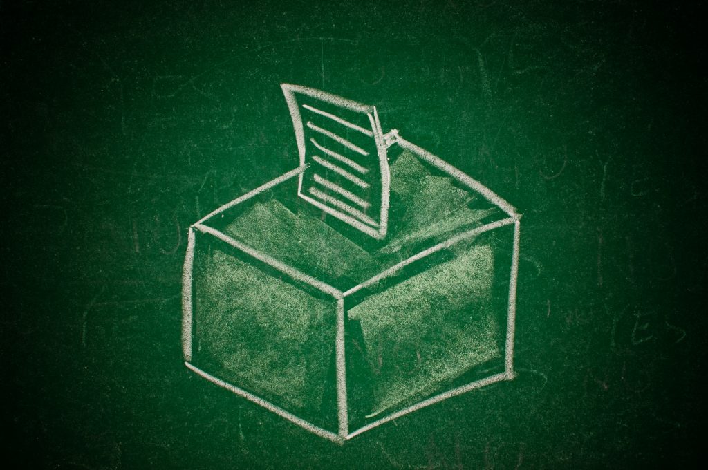 Vote concept; handdrawn ballot box on a green chalkboard