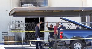 Fire investigators stand outside the Arizona Democratic Party headquarters Friday, July 24, 2020, in Phoenix. Fire investigators are looking into the cause of an early morning blaze that destroyed part of the Arizona and Maricopa County Democratic Party headquarters Friday. (AP Photo/Matt York)