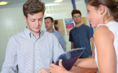 In this photo illustration a signature gatherer hands a clipboard to a man to sign.