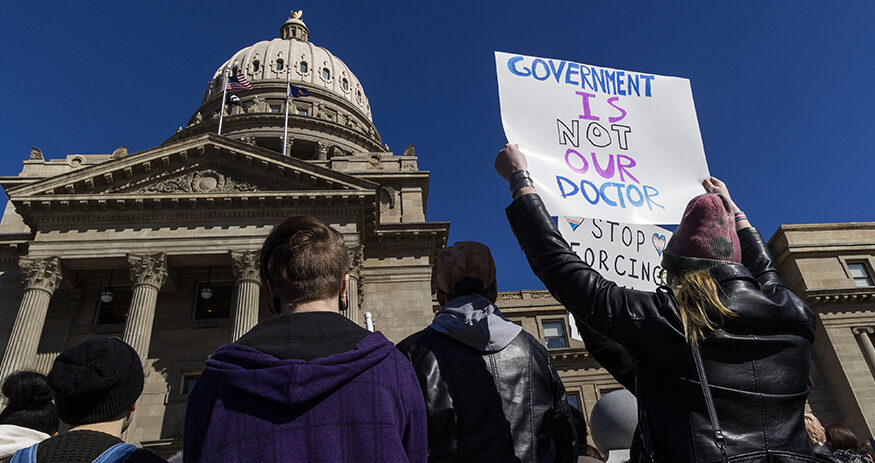 People gather in front of the Idaho Statehouse in opposition to anti-transgender legislation moving through an Idaho Republican congress, Friday, Feb. 24, 2023, in Boise, Idaho. The U.S. Supreme Court's decision on Monday, April 15, 2024, allows the state to put in place a 2023 law that subjects physicians to up to 10 years in prison if they provide hormones, puberty blockers or other gender-affirming care to people under age 18. A federal judge in Idaho had previously blocked the law in its entirety.