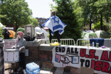 Counter protester Caren Ayden, of Pikesville, Md., carries an Israeli flag as pro-Palestinian students demonstration against the Israel-Hamas war at George Washington University in Washington, Sunday, April 28, 2024. Protests and encampments have sprung up on college and university campuses across the country to protest the war. (AP Photo/Cliff Owen)