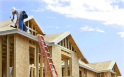 A construction roofer works on the frame of a roof at a new housing development on Friday, April 6, 2007 in Phoenix.